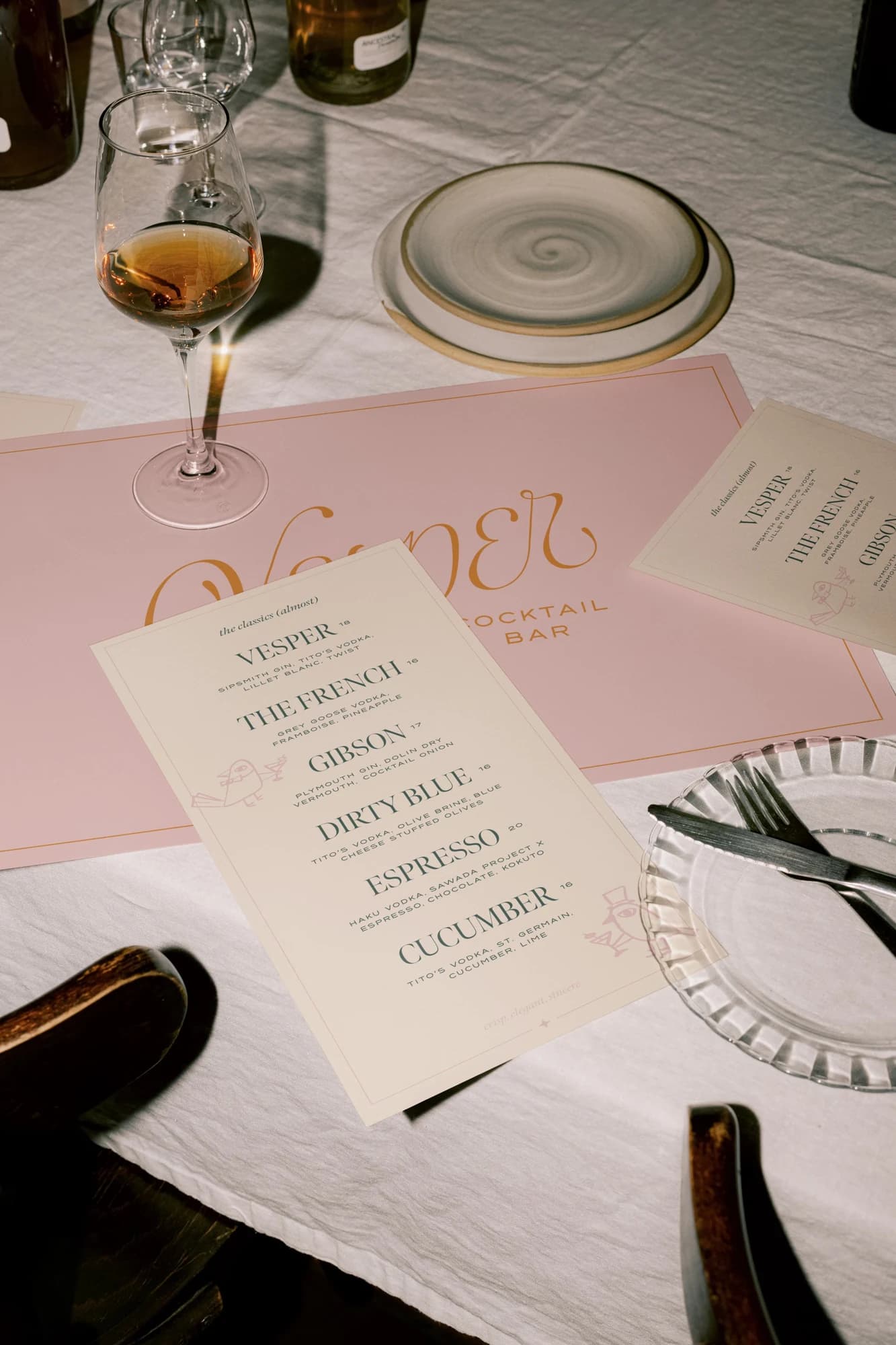 Vesper cocktail menus arranged on a warmly lit table